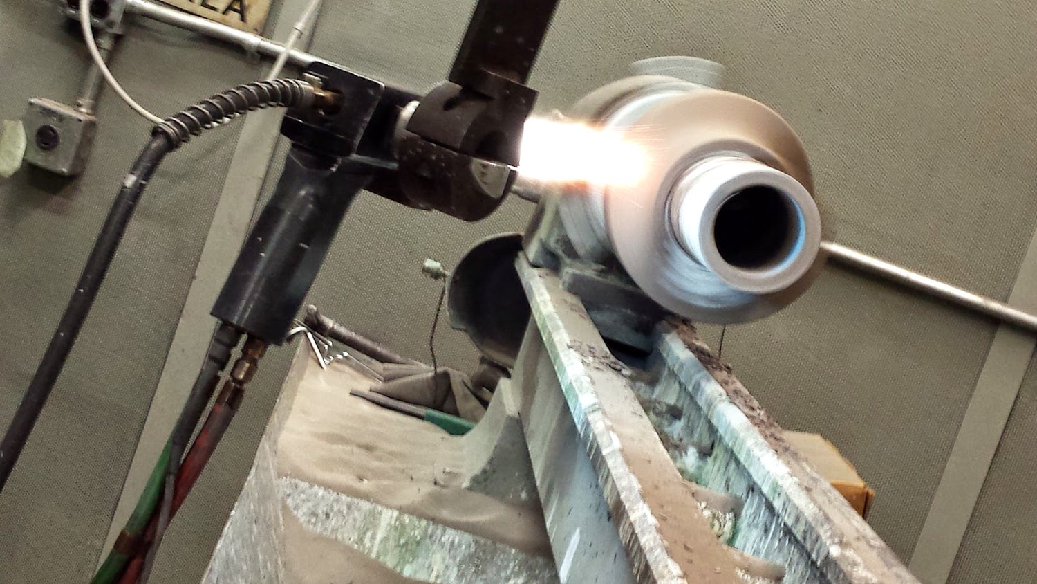 A torch arc on a tube joint held in a fixture